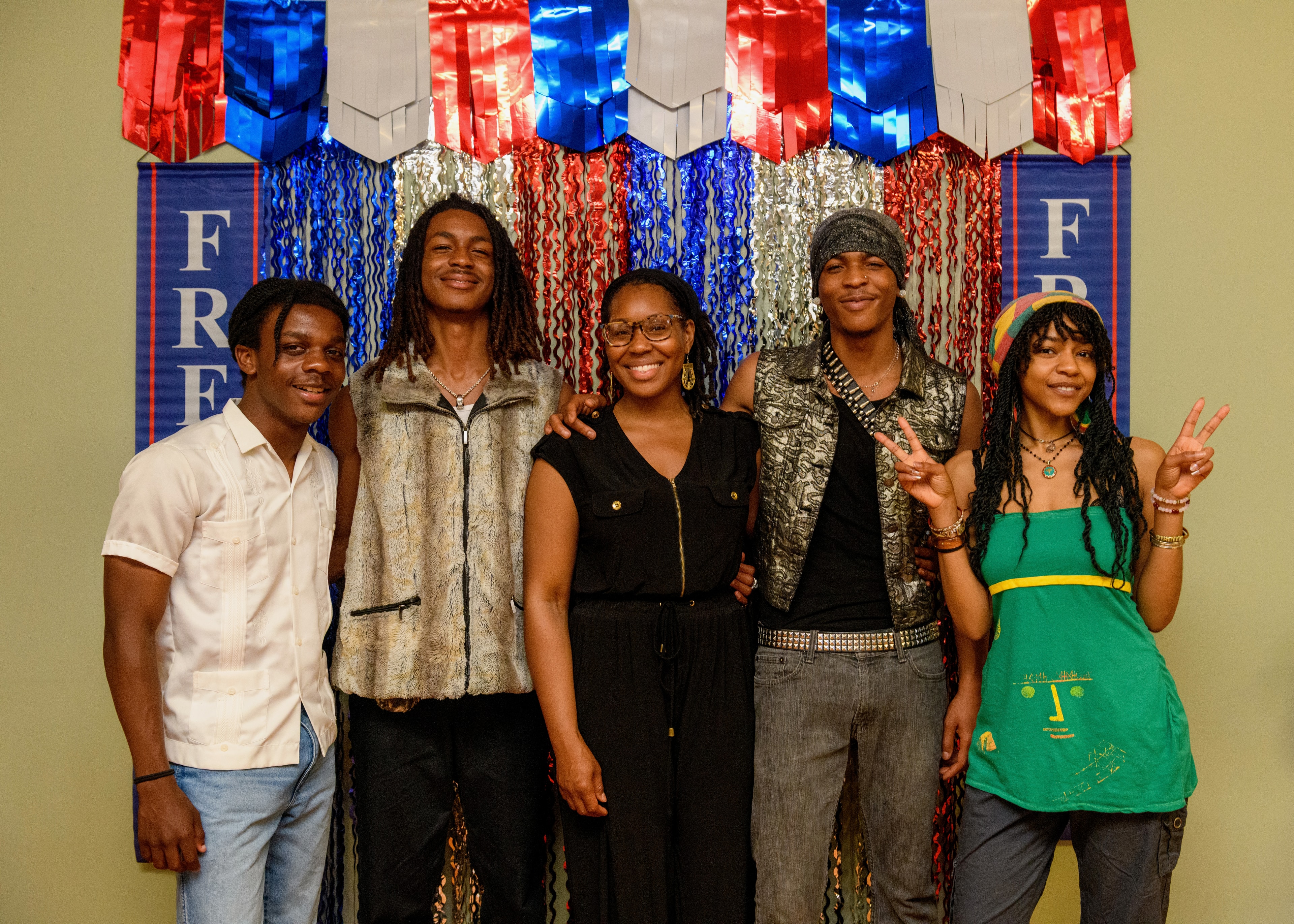 Five Juneteenth Jubilee attendees posing together in front of a festive red, white, and blue celebration backdrop.